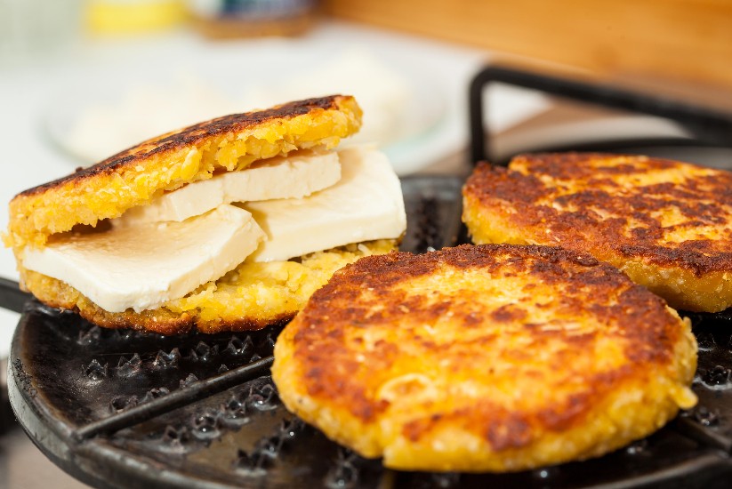 Arepa de chócolo en una sartén.